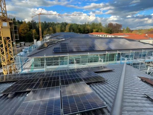 Aerial view of a second residential solar rooftop installation with skylights and garden