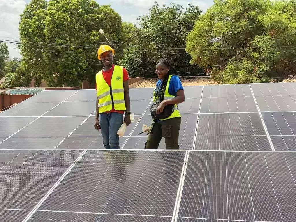 E-Able Power partner technicians in safety vests inspecting a rooftop solar array installation
