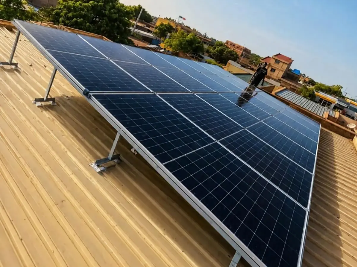 Solar panel array being installed on a corrugated metal roof by an installer